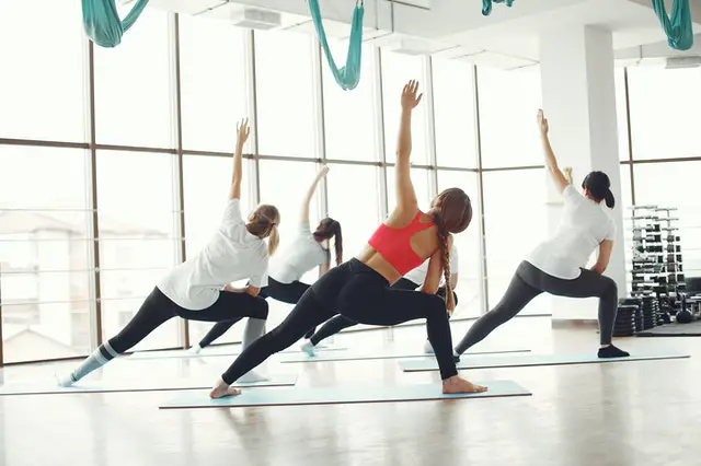 group of actresses working out and doing Pilates in a bright spacious gym
