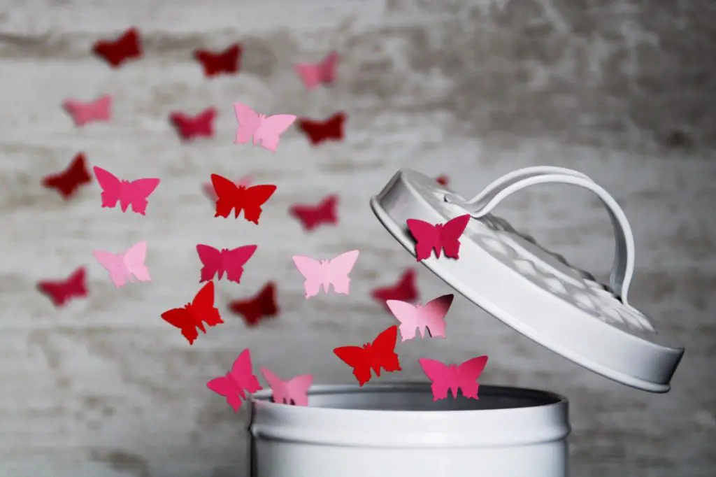 let go of ideas like these pink and red paper butterflies leaving the garbage bin