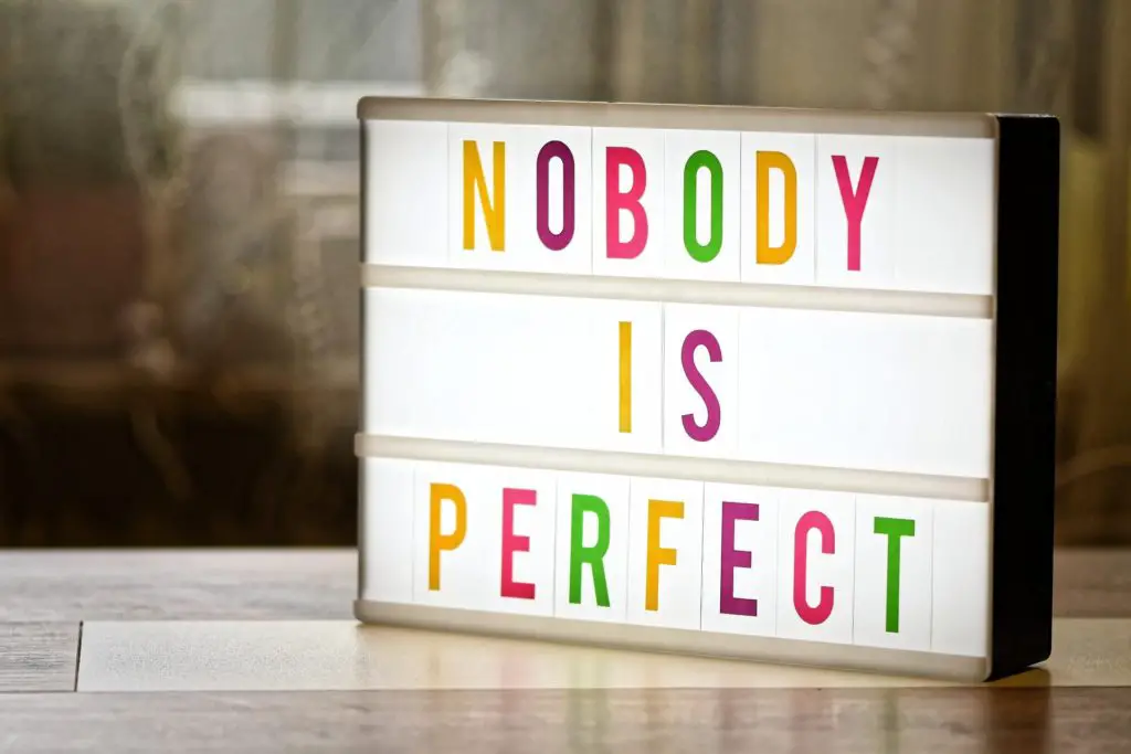 let go of trying to be perfect as nobody is perfect shown on the sign