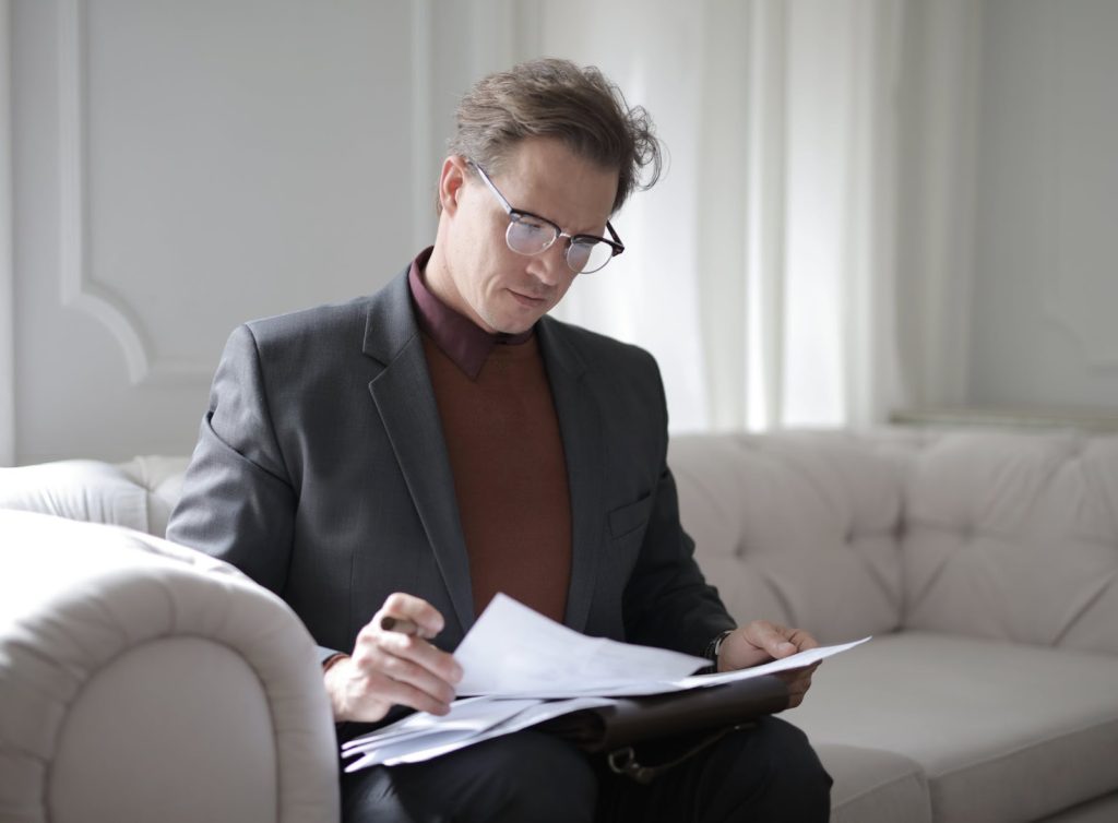 A man sitting on a sofa reading a script